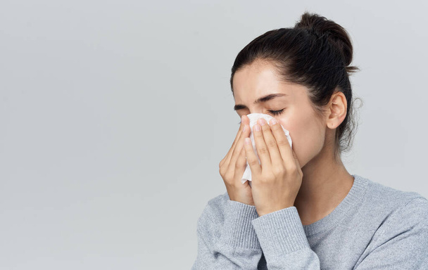 femme souffle son nez dans une serviette nez liquide problèmes de santé fond gris - Photo, image