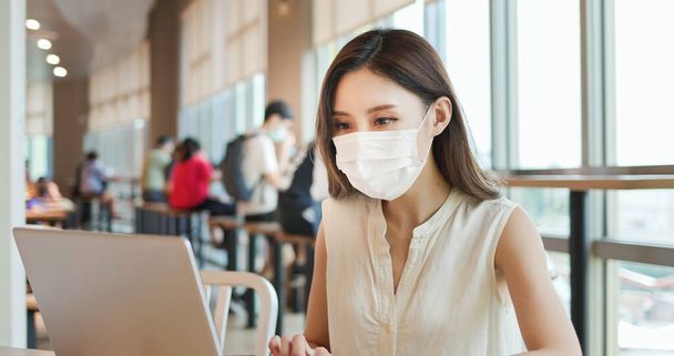 asian young woman has remote work in coffee shop or restaurant with surgical face mask - Φωτογραφία, εικόνα