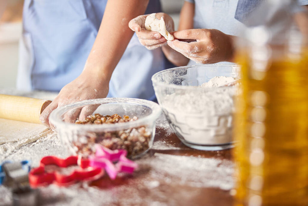 Hands of people involved in kneading dough in kitchen - 写真・画像