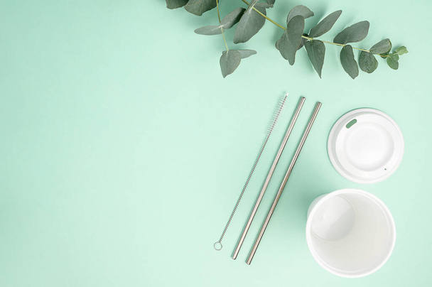 Stylish reusable eco coffee cup and metallic steel straws on green , flat lay. Ban single use plastic, zero waste concept. Cup and reusable straws. Sustainable lifestyle. High quality photo - Foto, afbeelding