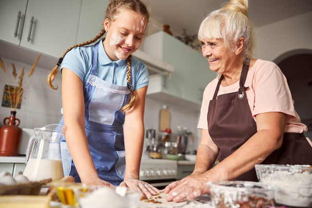 Happy grandmother feeling proud of her granddaughter culinary skills - Photo, Image