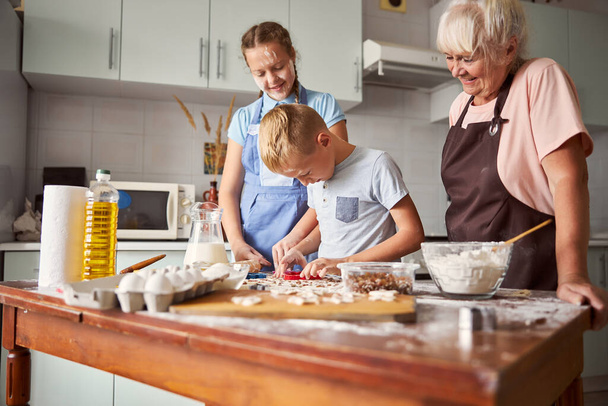 Familia feliz aprendiendo a cocinar en casa - Foto, Imagen