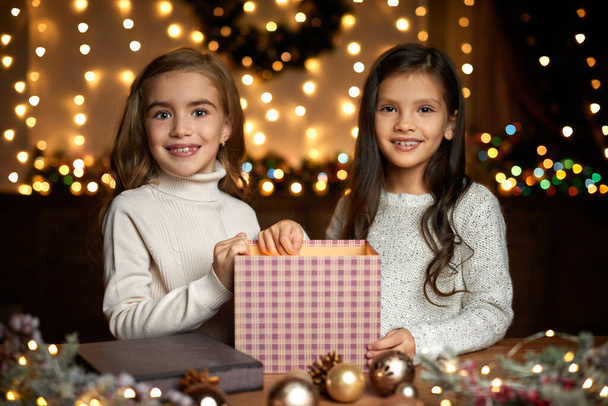 little child girl opening magic Christmas gift box - Foto, afbeelding