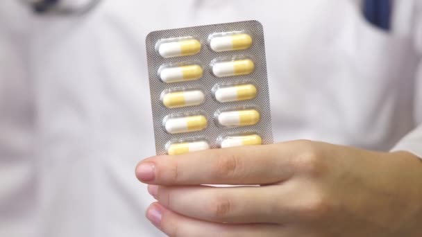 Біль релакс таблетки в жіночій руці медичного працівника в білому пальто. Капсули з ліками, прийом ліків, охорона здоров'я, фармація та концепція лікування, крупним планом
 - Кадри, відео