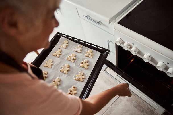 Femme âgée qualifiée sur le point de faire cuire des biscuits - Photo, image