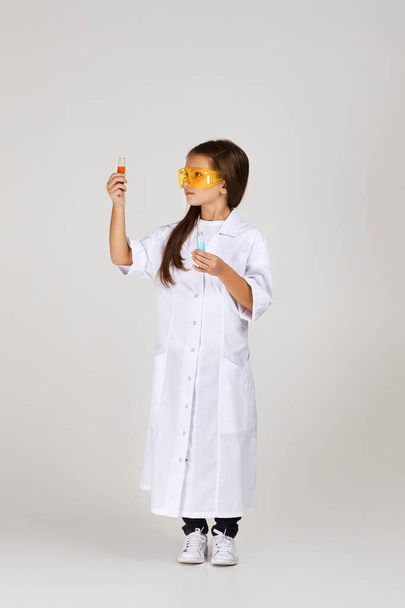 little child girl holding a chemical flask and test tube - Photo, image