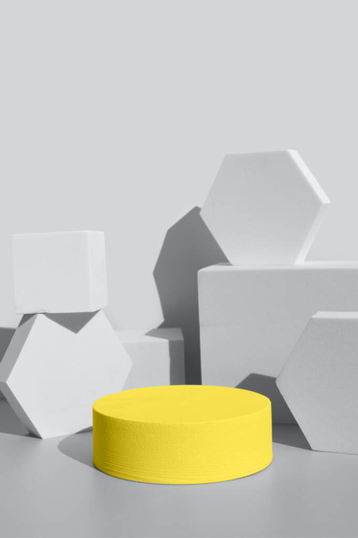 formas geométricas tonificadas gris final y una pantalla de podio amarillo iluminador - Foto, imagen
