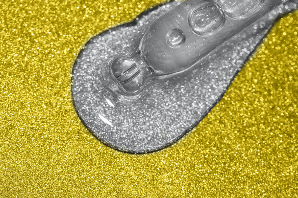 macro de pipette avec liquide coulant sur fond de paillettes - Photo, image