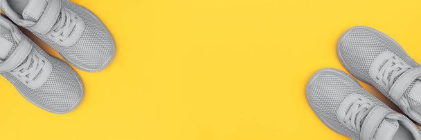 Szürke sportcipők zászlója sárga háttérrel. Új cipők sárga pasztell háttérrel. Fogyás és sport koncepció. Top view, flat lay, copy space. Bemutató trendi színek 2021 - Szürke és sárga - Fotó, kép