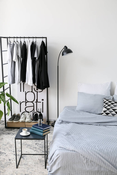 Interior of stylish bedroom with clothes rack - Fotoğraf, Görsel