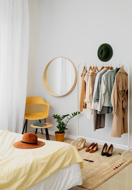 Interior of stylish bedroom with clothes rack - Foto, Imagem
