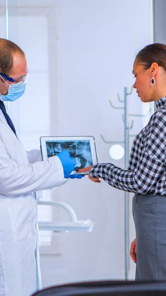 Fogorvos a váróban beszél a nő beteg a röntgen - Fotó, kép