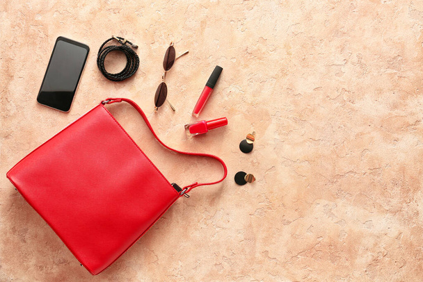 Elegante bolso, accesorios y teléfono móvil sobre fondo de color - Foto, Imagen