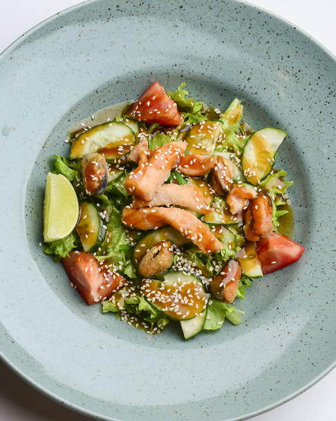Baked salmon salad with tomatoes, cucumbers, avocado. Asian cuisine concept, delicious dinner idea. - Foto, immagini
