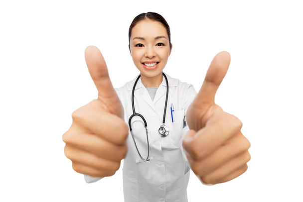 smiling asian female doctor showing thumbs up - Zdjęcie, obraz