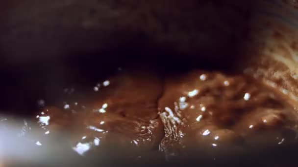 Ev yapımı Sıvı Çikolata. Metalik bir tavada erimiş siyah çikolata. Sıcak sütle karıştırılmış çikolata eritme işlemi. 4K video - Video, Çekim
