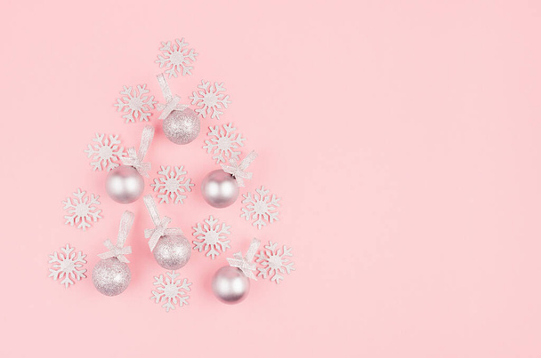 Elegant simple christmas tree of silver glittering balls with ribbon and snowflakes on pastel pink backdrop, top view, copy space. - Zdjęcie, obraz