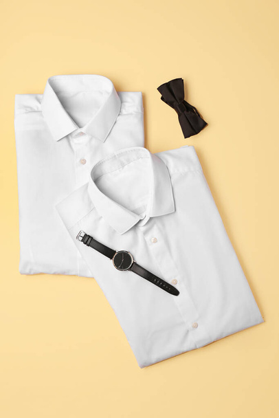 Nuevas camisas masculinas, reloj de pulsera y corbata de lazo en el fondo de color - Foto, imagen