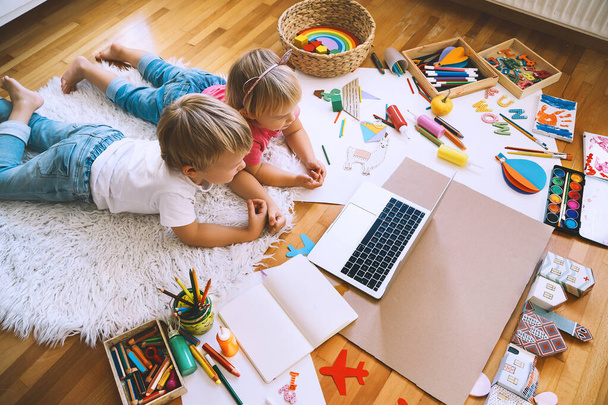Kids drawing and making crafts with online art classes at home. Children using laptop to distance online education. Background for preschool, kindergarten or family daycare. Childcare and technology. - Photo, image