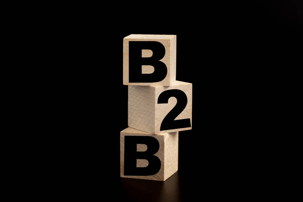 Proceso de éxito del concepto empresarial. B2B escrito sobre un cubo de madera sobre fondo negro - Foto, Imagen