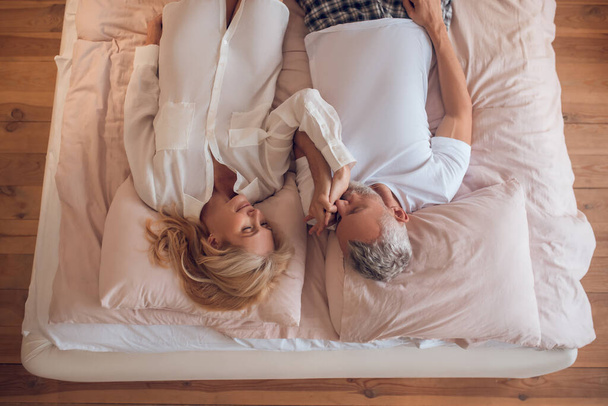 Married couple lying on a bed and looking peaceful - Foto, Imagem