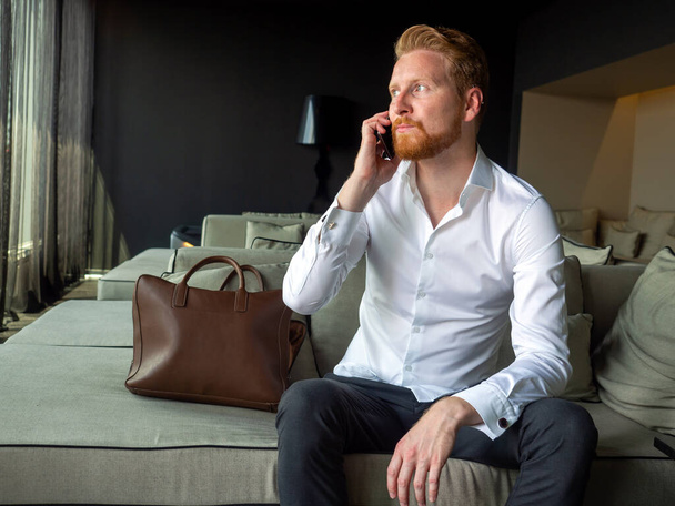 Portrét pohledného mladého podnikatele na telefonu v kanceláři - Fotografie, Obrázek