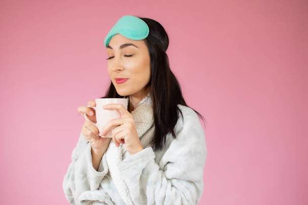 Jeune femme heureuse et gaie en vêtements de couchage tenant une tasse de café - Photo, image