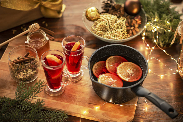 Red mulled wine on the table, Christmas decorations in the background. - Foto, immagini