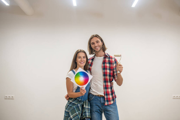 Young couple discussing the color for walls and looking happy - Фото, зображення