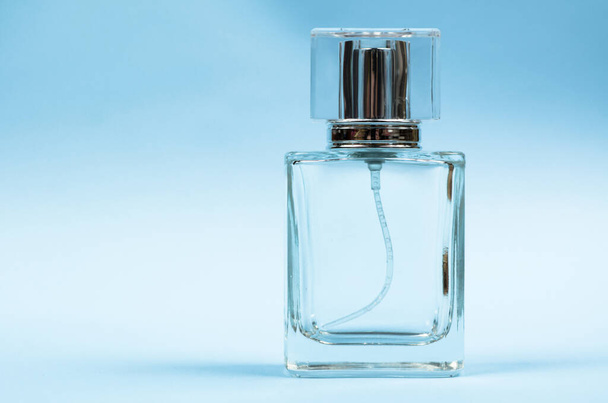 Male perfume bottle on blue background close up - Foto, afbeelding