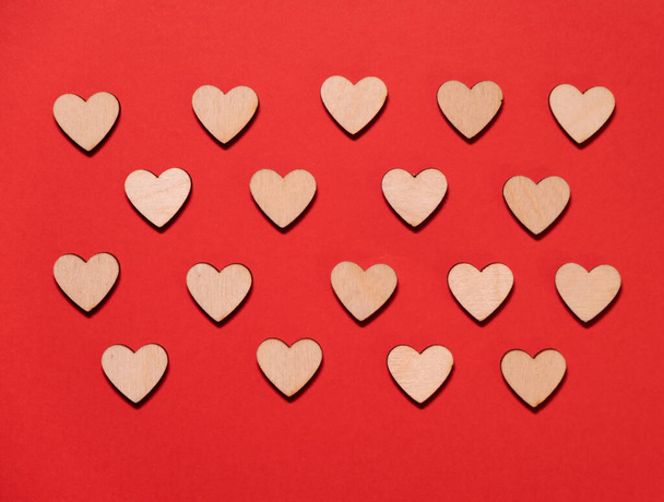 Fából készült szívek piros háttérrel, szöveges szöveggel. Valentin-nap, anyák napja. - Fotó, kép