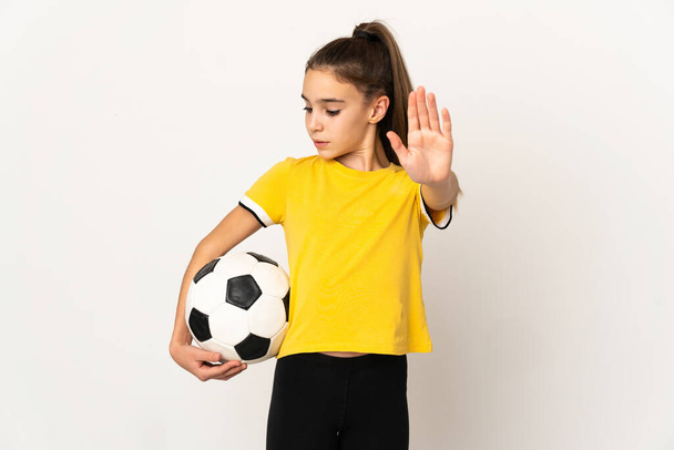 Piccola ragazza giocatore di calcio isolato su sfondo bianco facendo gesto di arresto e deluso - Foto, immagini