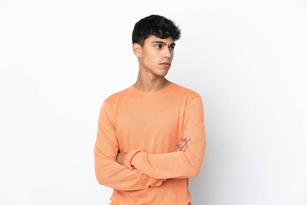 Young man over isolated white background keeping the arms crossed - Φωτογραφία, εικόνα