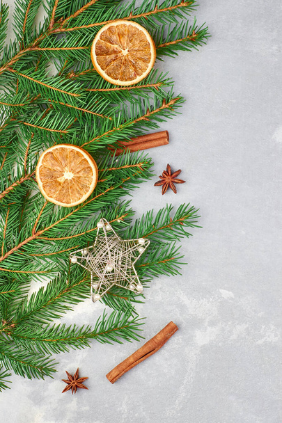 Noel kompozisyonu köknar ağacı dalları, kuru portakal dilimleri, anason yıldızları ve tarçın çubukları. Noel düzlüğü, üst manzara. - Fotoğraf, Görsel