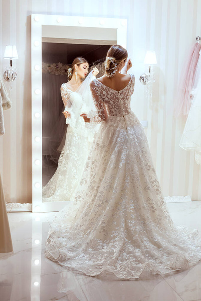 Retrato de una hermosa novia en un vestido de novia en el espejo. - Foto, imagen