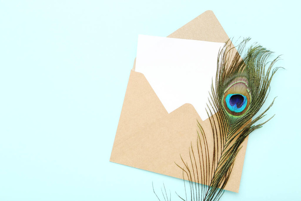 Peacock feather with envelope on mint background - Photo, Image