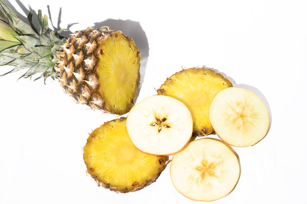 ломтики свежего спелого ананаса и яблока на белом фоне, концепция здоровой пищи, близкий взгляд  - Фото, изображение