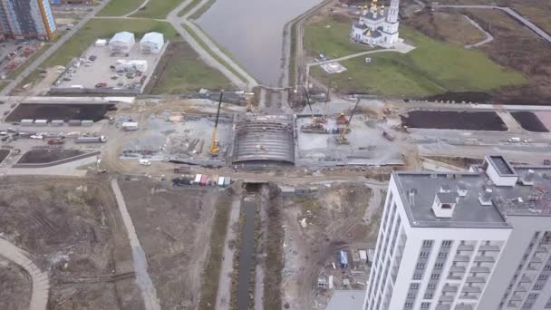 Ekaterinburg, Russia. La costruzione di un ponte sul fiume. Nuova area di costruzione Akademicheskiy (Accademico). 4K - Filmati, video