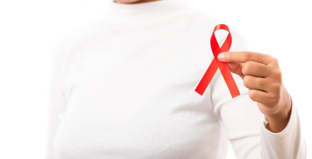 スタジオでHIVエイズ意識の赤いリボンを持つ女性が白い背景に隔離されたショット、医療や医療、世界エイズデーのコンセプト - 写真・画像
