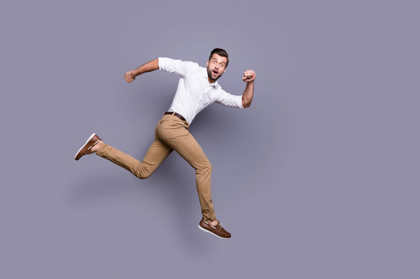 Full length body size view of his he nice attractive elegant trendy cheerful funky energetic man jumping running ambition late isolated over grey violet purple pastel color background - Fotografie, Obrázek