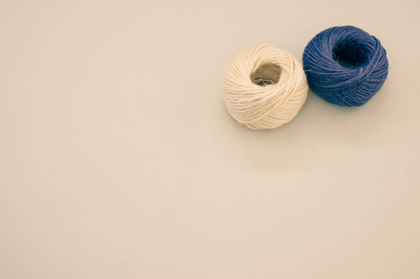 A high angle shot of blue and beige yarns isolated on a beige background - Fotó, kép