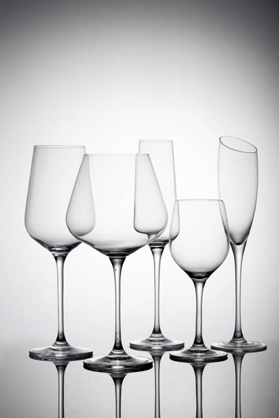 A vertical shot of champagne and wine glasses with shadow on a white background - Foto, imagen