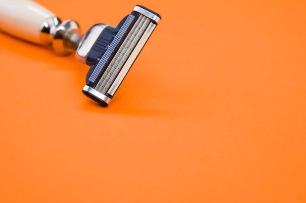A closeup shot of a man's razor on orange background - Фото, зображення