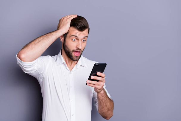 Close-up portrait of his he nice attractive amazed stunned overwhelmed brunet guy employer using digital device 5g app browsing incredible news isolated over gray pastel color background - Photo, image