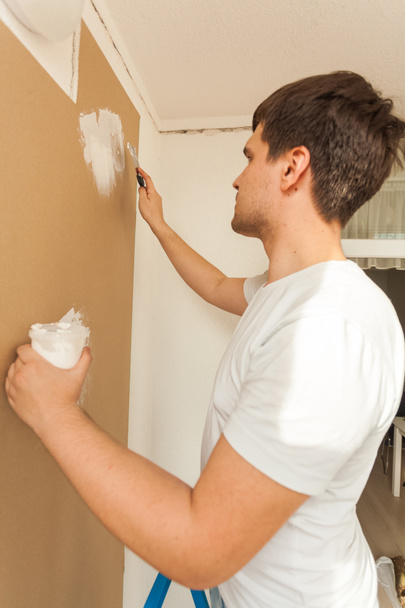 Portrait of young man aligning wall with putty - Photo, Image