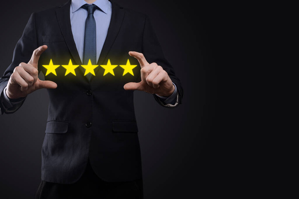 Man hand tonen op vijf sterren uitstekende rating.pointing vijf sterren symbool om de rating van het bedrijf te verhogen.Review, verhoging van de rating of ranking, evaluatie en classificatie concept. - Foto, afbeelding
