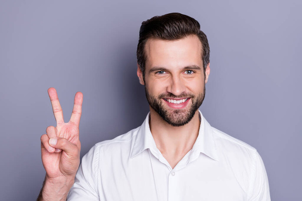 Close-up portrait of his he nice attractive content cheerful cheery brunet guy executive director employee sales manager colleague it expert showing v-sign isolated over gray pastel color background - Photo, image