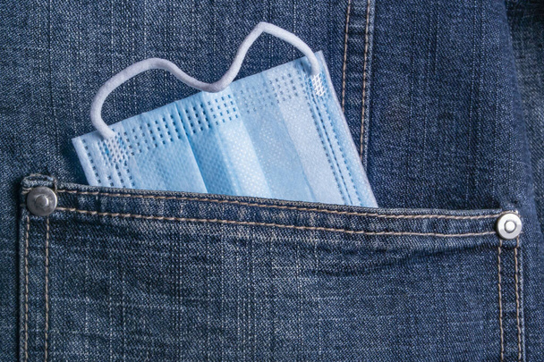 orvosi védőmaszk áll ki a farmerdzseki zsebéből - Fotó, kép