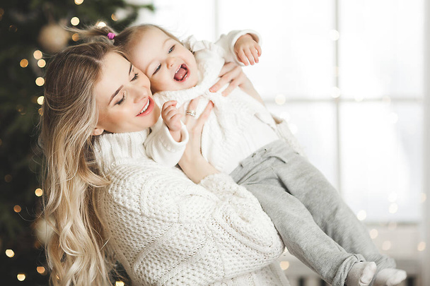 Young mother with her little daughter on christmas background - Foto, Imagem