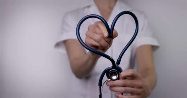 vrouwelijke arts met hartvormige stethoscoop. liefde voor werk in de gezondheidszorg, cardiologie of ziektekostenverzekering. kopieerruimte - Video